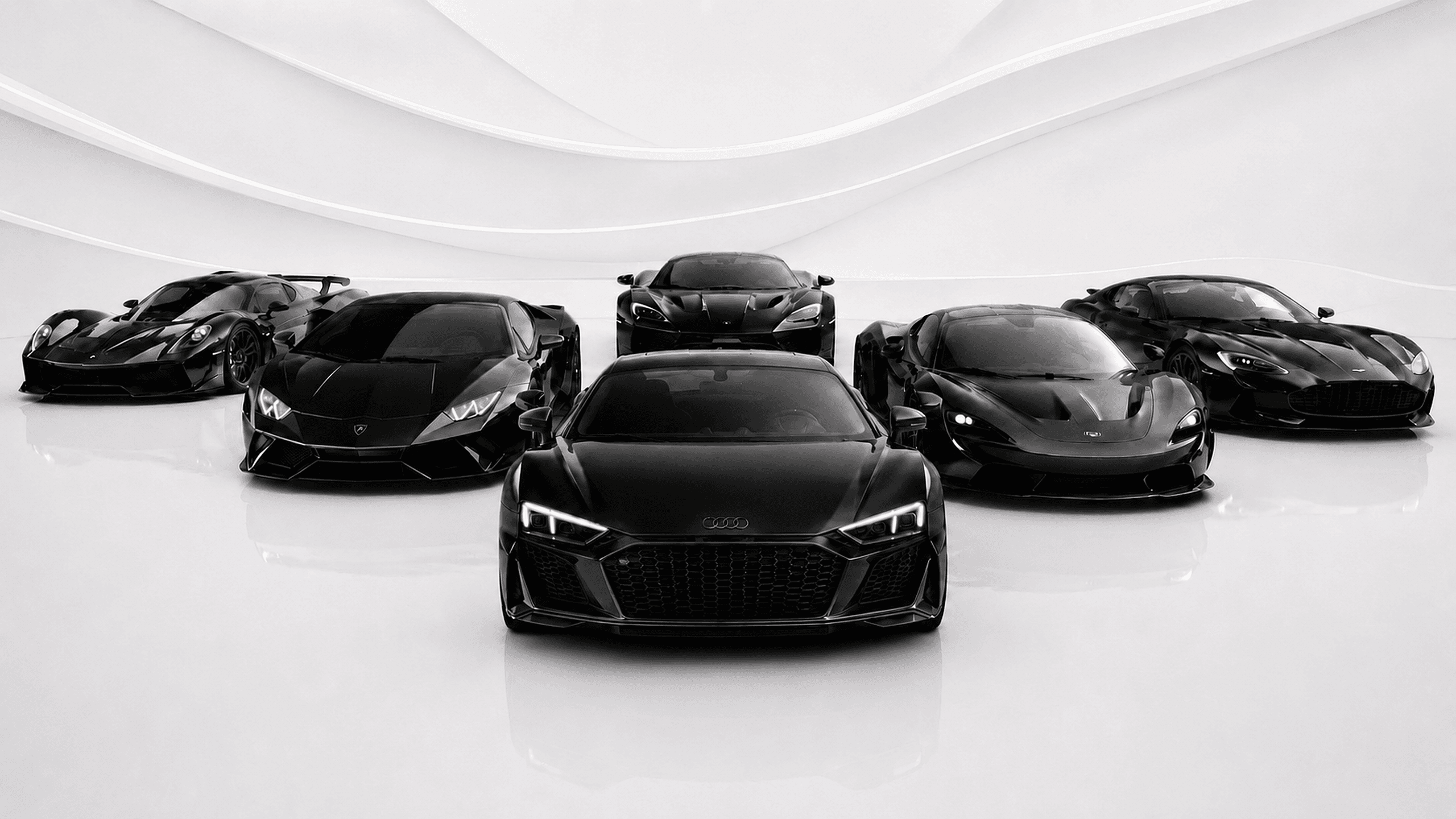 The ASCND collection — a lineup of black supercars in the showroom